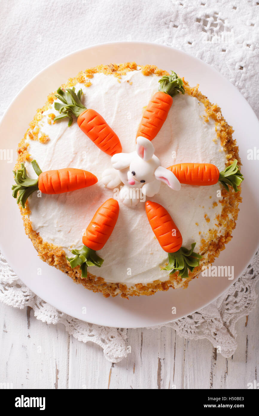 Schöne Karottenkuchen mit Bonbon Bunny Nahaufnahme auf dem Tisch. vertikale Ansicht von oben Stockfoto