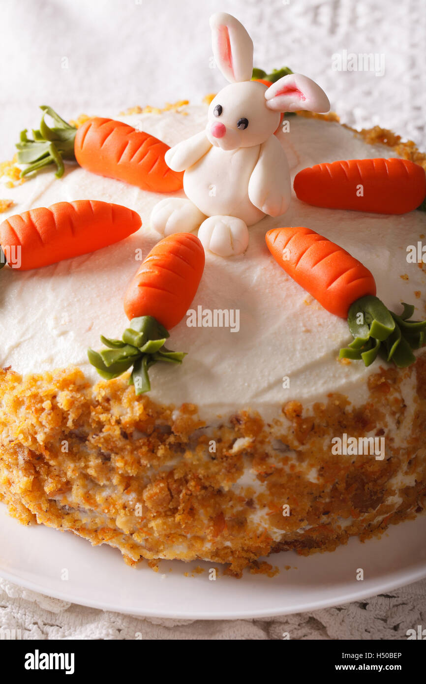 Karottenkuchen mit Bonbon Bunny Nahaufnahme auf einem Teller auf den Tisch. Vertikal Stockfoto