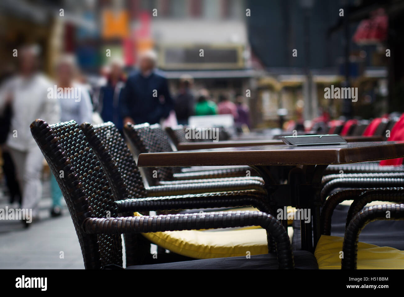 Tische und Stühle auf der Terrasse vor dem Restaurant mit Menschen zu Fuß durch im Hintergrund Stockfoto