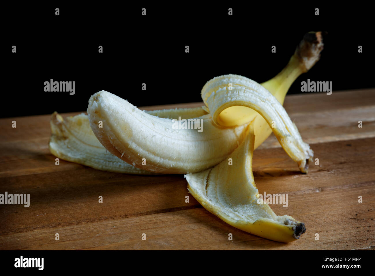 geschälte Banane auf einem rustikalen Tisch closeup Stockfoto