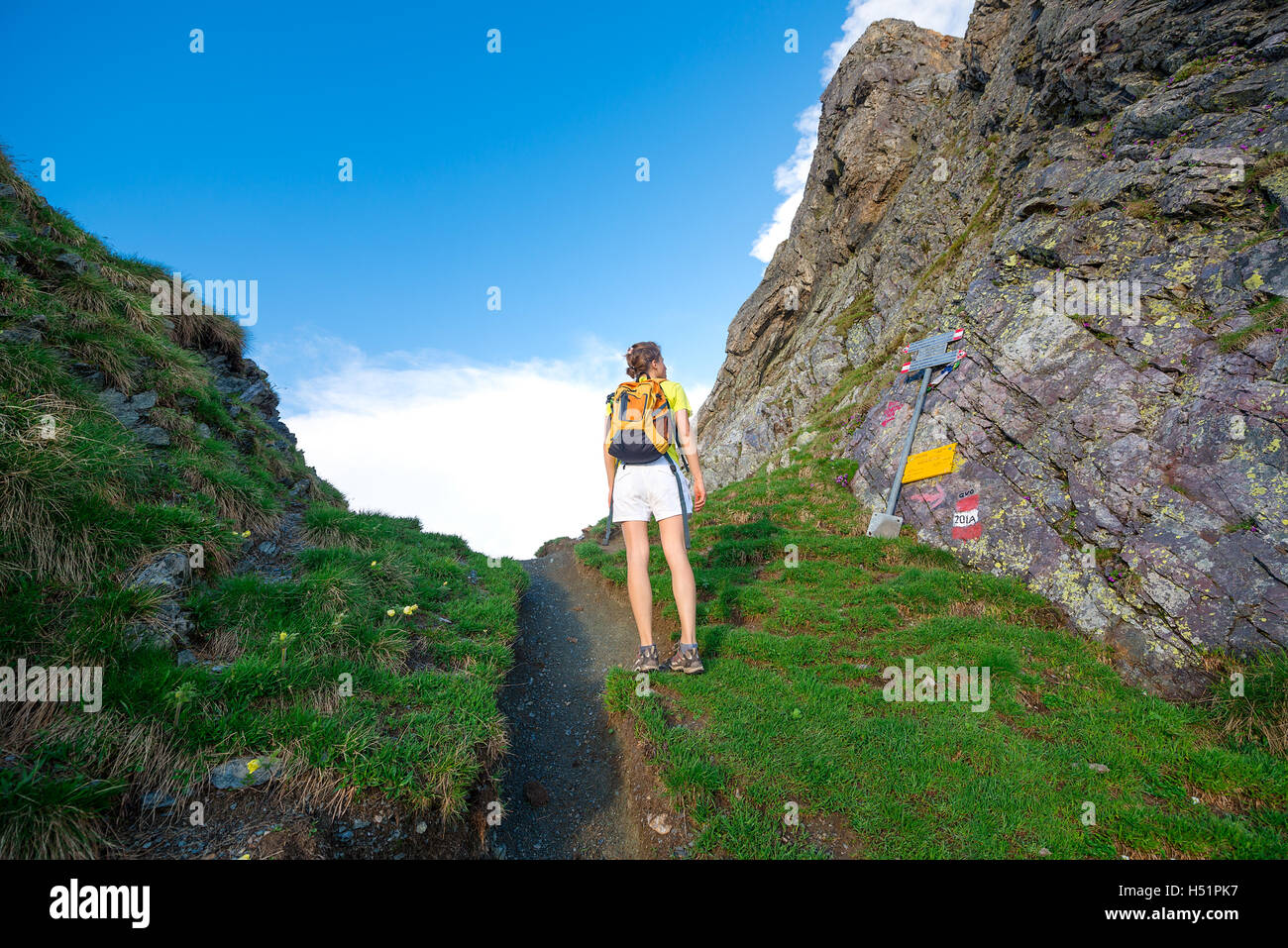 Mädchen sieht Anzeichen Bergweg in einem Bergpass Stockfoto