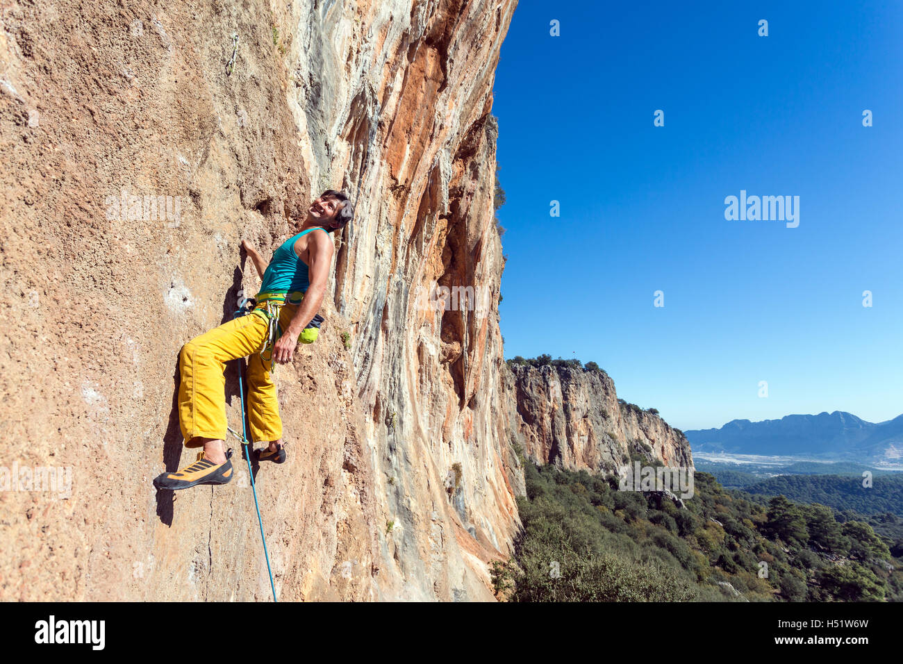 Lächelnd Reifen männlichen Extrembergsteiger Felswand einfach hängen Stockfoto