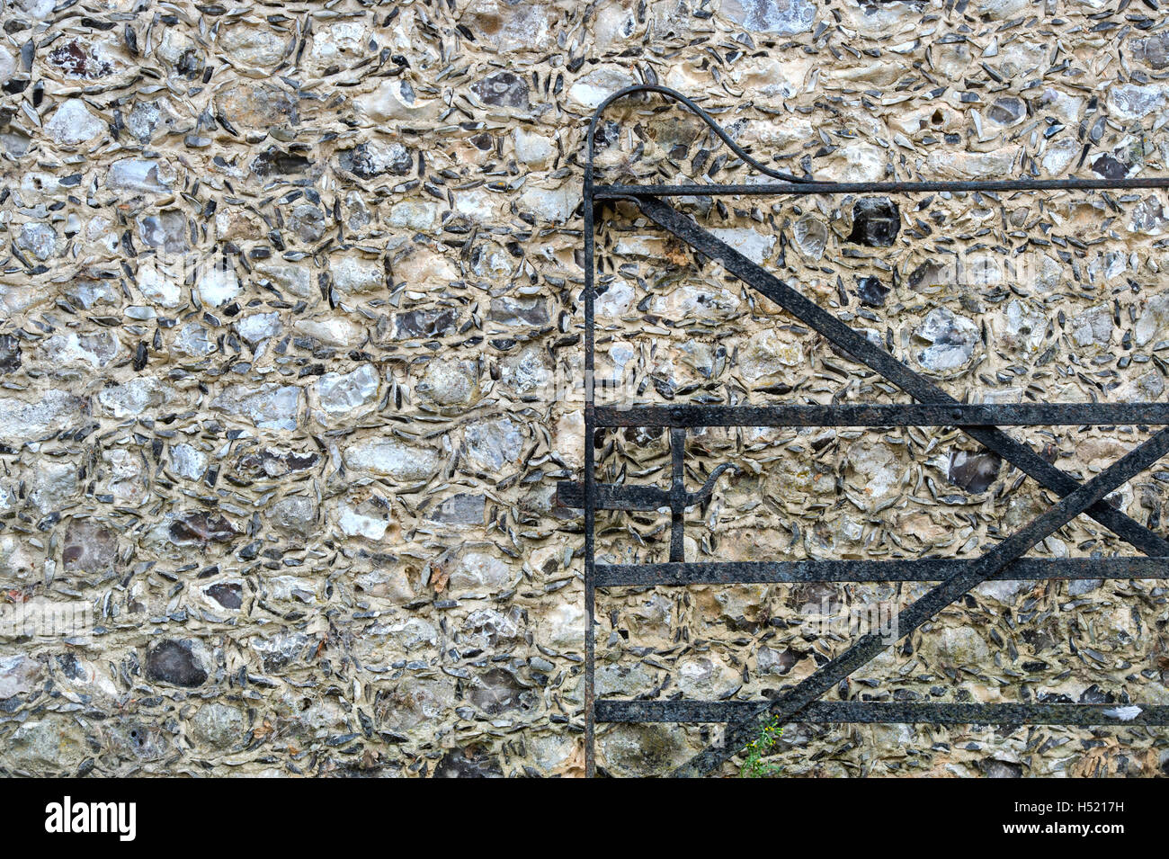 Schmiedeeisernes Tor vor einem Feuerstein und Steingebäude Wand Weald und Downland Freilichtmuseum, Singleton, Sussex, England Stockfoto