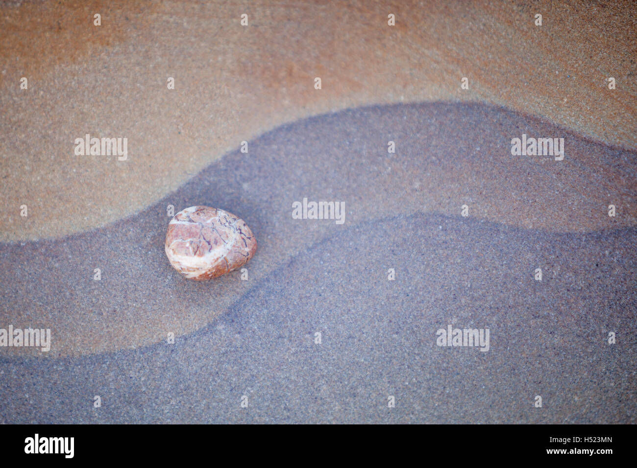 Abstrakte Rock Muster und bunte, Flieder, lila und Oranage Felsen am Strand, Kiesel und Geologie Stockfoto