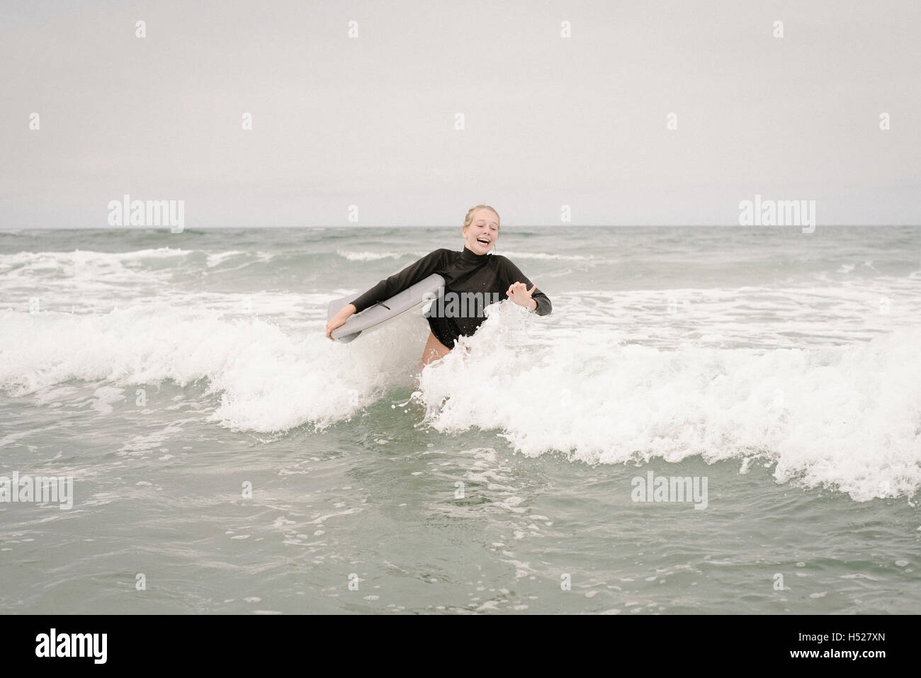 Blonde Mädchen Bodyboarden im Ozean. Stockfoto