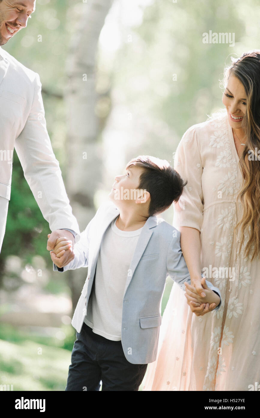 Vater, Mutter und Sohn gehen im Freien, Hand in Hand. Stockfoto