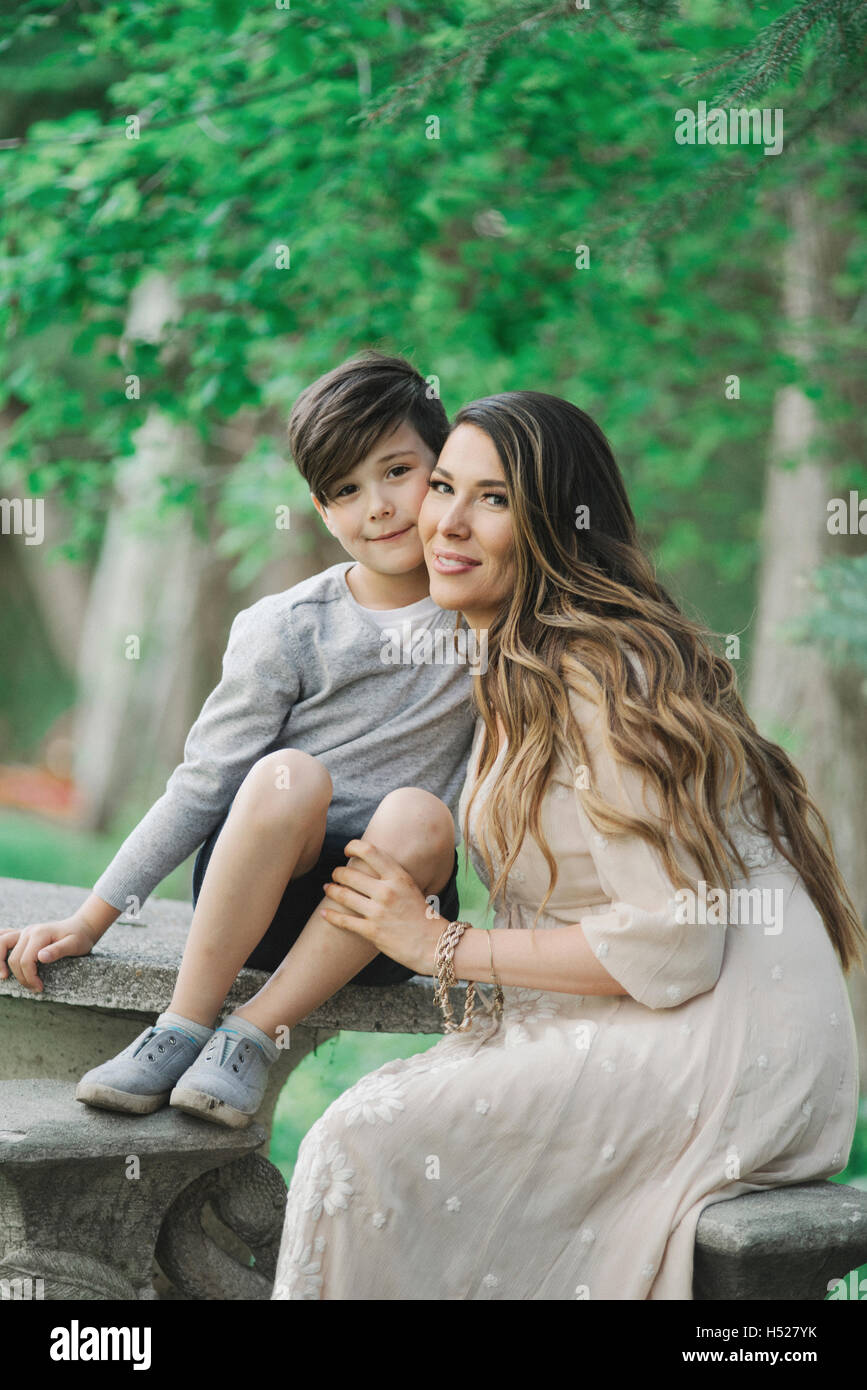 Porträt einer lächelnden Mutter und Sohn sitzen in einem Garten. Stockfoto