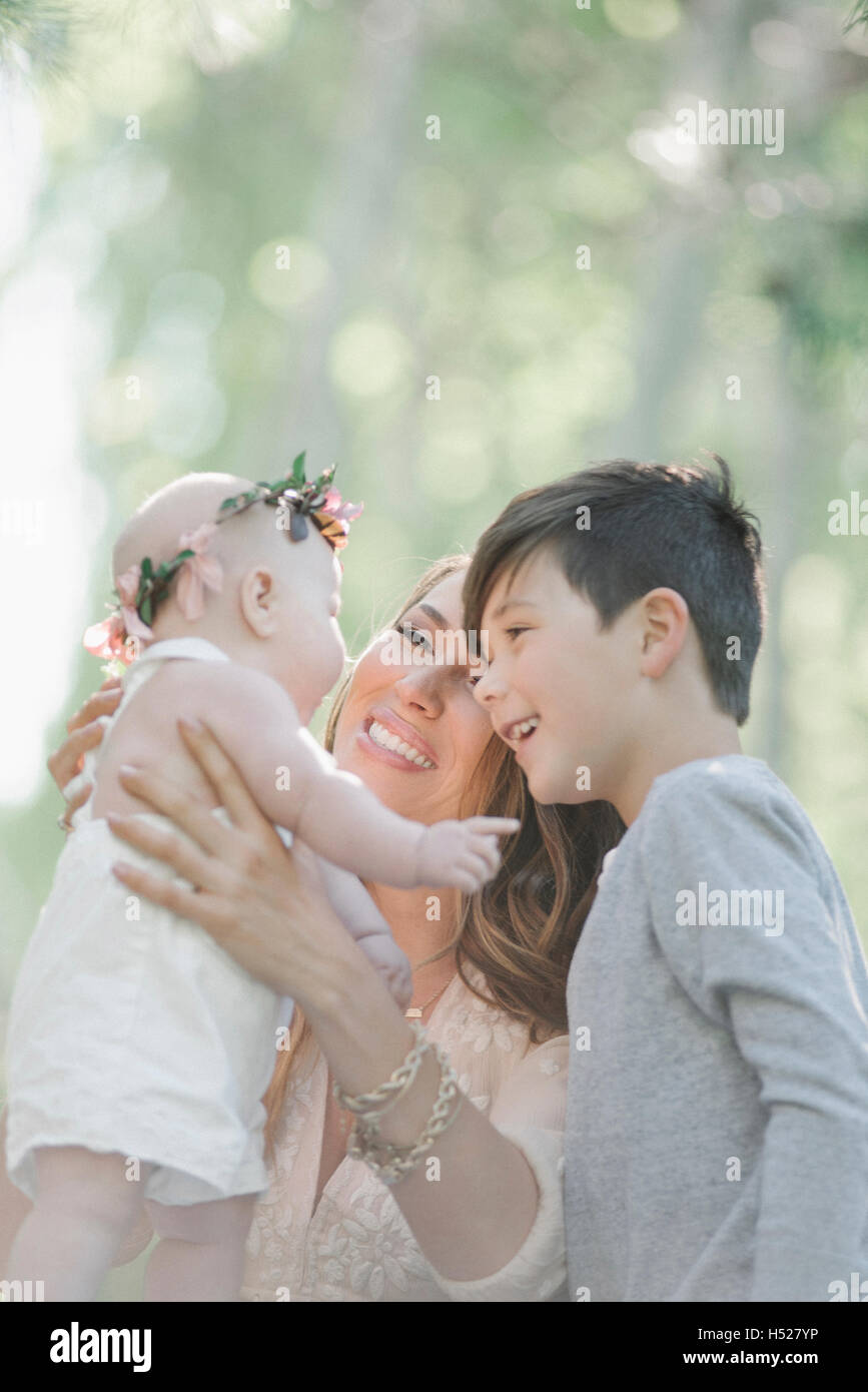 Porträt von einem lächelnden Baby, Mutter und junge Mädchen mit einem Blumen-Kranz auf dem Kopf. Stockfoto
