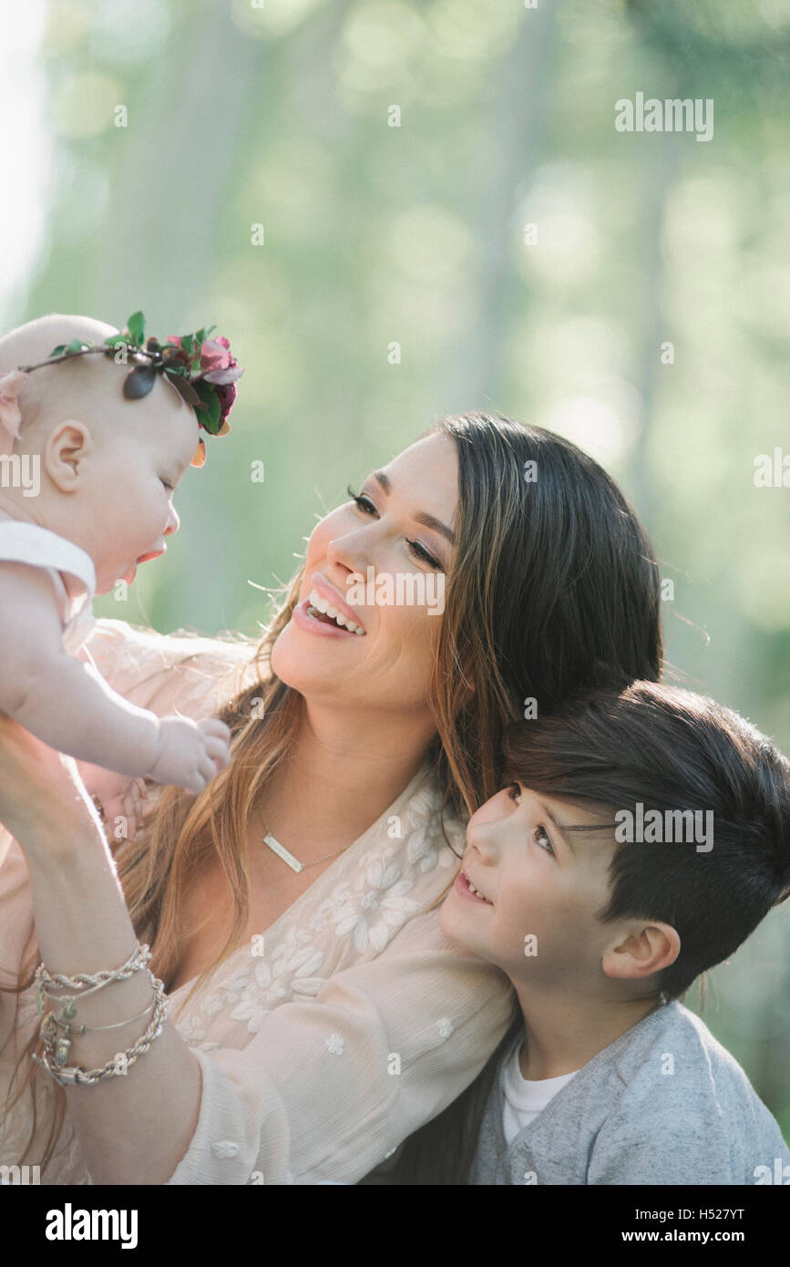 Porträt von einem lächelnden Baby, Mutter und junge Mädchen mit einem Blumen-Kranz auf dem Kopf. Stockfoto