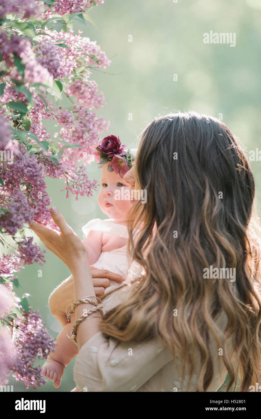 Mutter mit Babymädchen mit einem Blumen-Kranz auf dem Kopf. Stockfoto