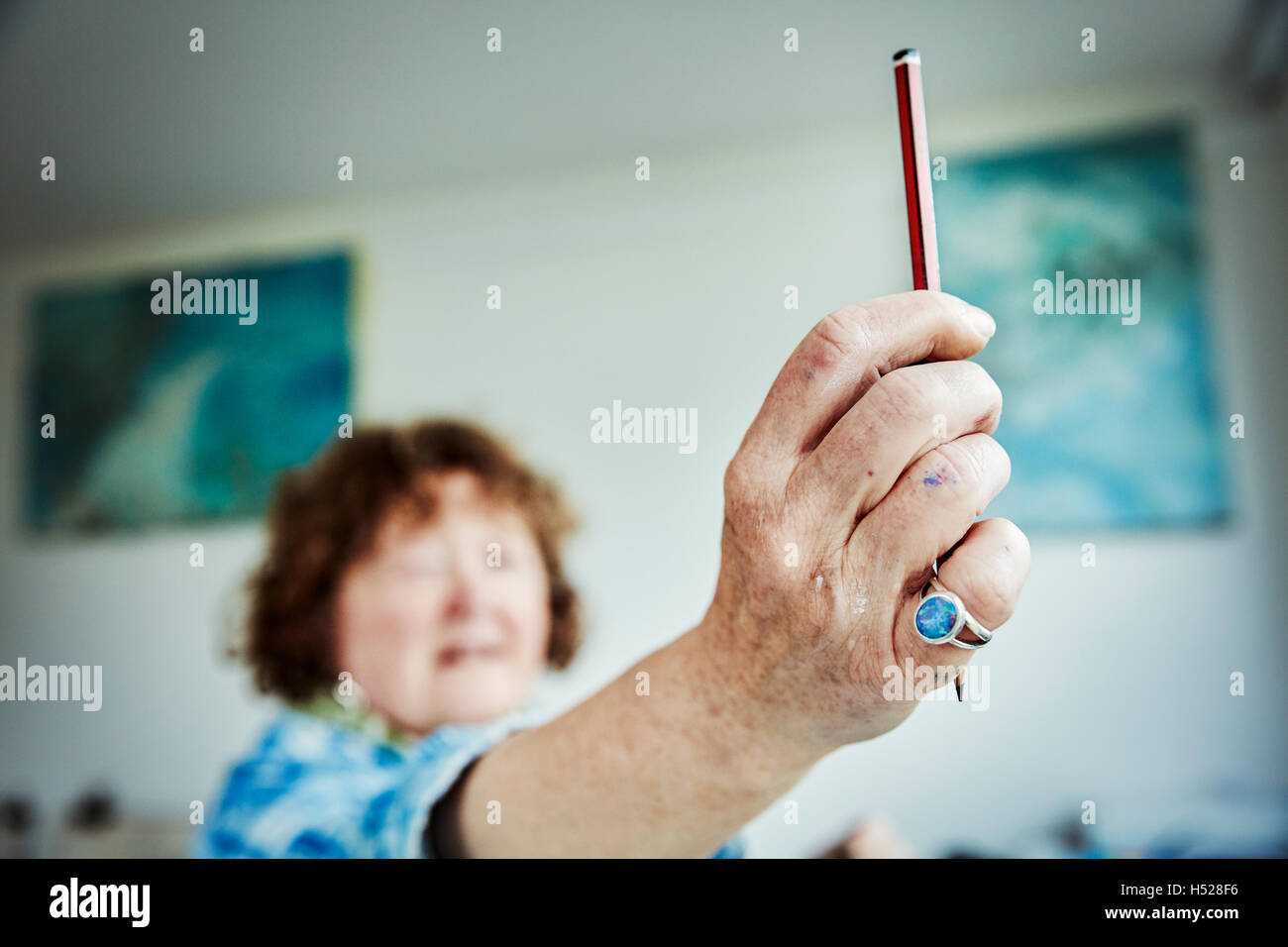 Eine Künstlerin arbeitet, hält einen Stift in der Hand für die Messung. Stockfoto