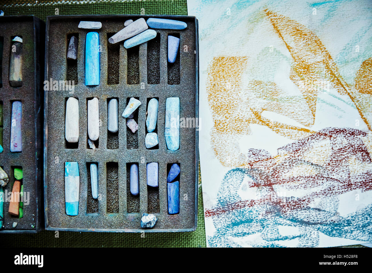 Eine Künstlerleinwand mit Kunstwerken in Fortschritt und Box Pastelle, Farben. Stockfoto