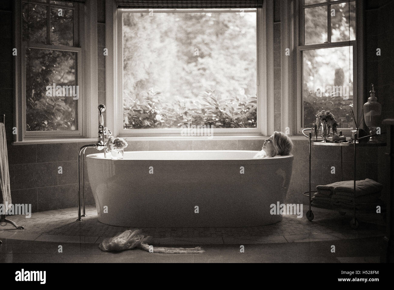 Frau liegend in einer freistehenden Badewanne. Stockfoto