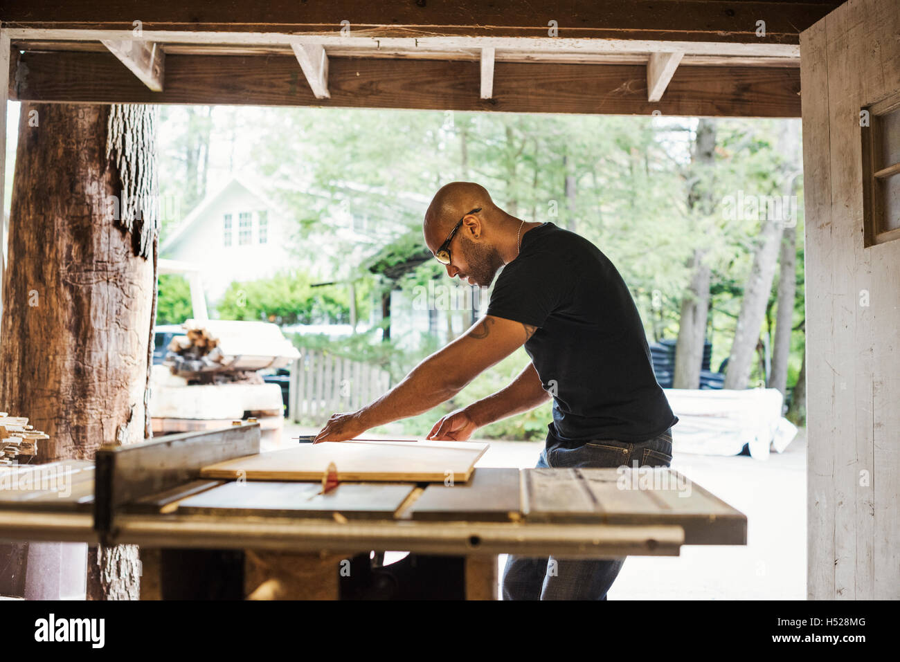 Mann mit Brille arbeiten in einem Holzlager. Stockfoto