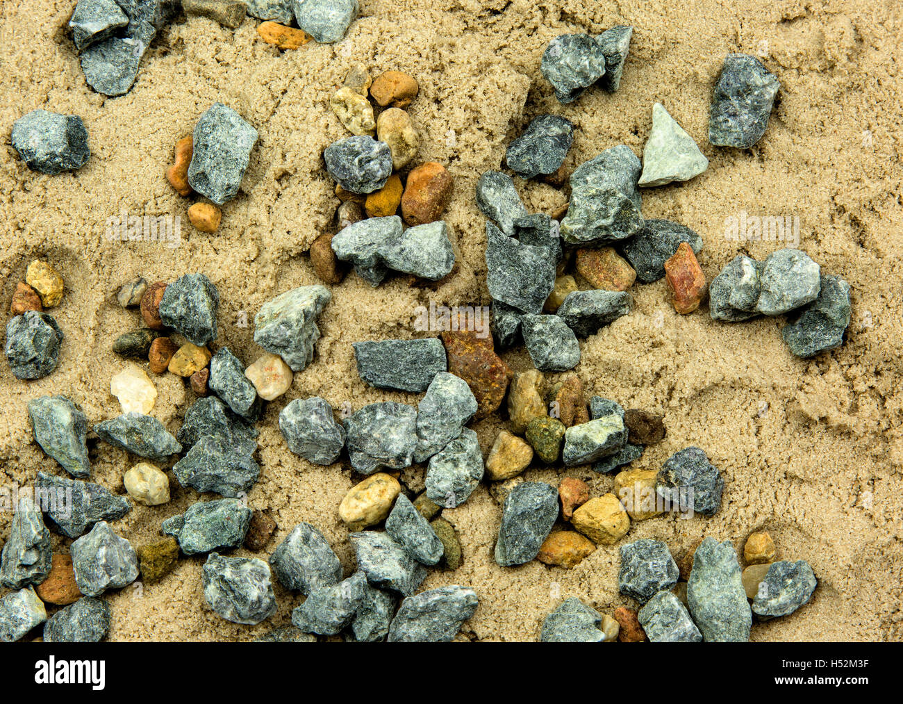Kleine Steinchen verstreut auf dem nassen Sand, in der Nähe der Flugzeug-Ansicht von oben. Interessanten natürlichen Hintergrund und Textur. Horizo Stockfoto
