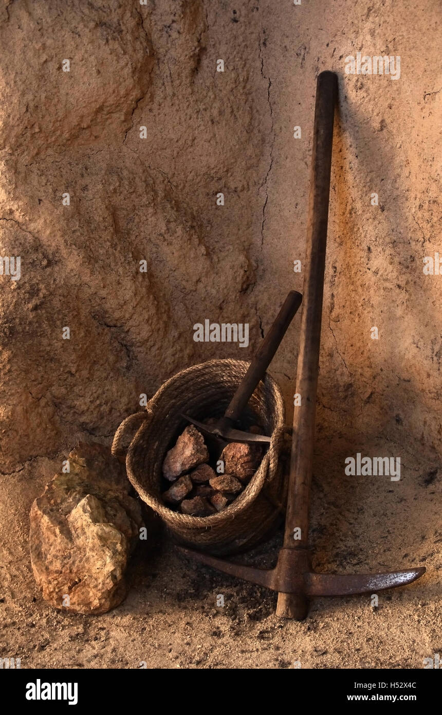 Alten Bergbauwerkzeuge und Korb voller Felsen in einem Tunnel in eine mine Stockfoto
