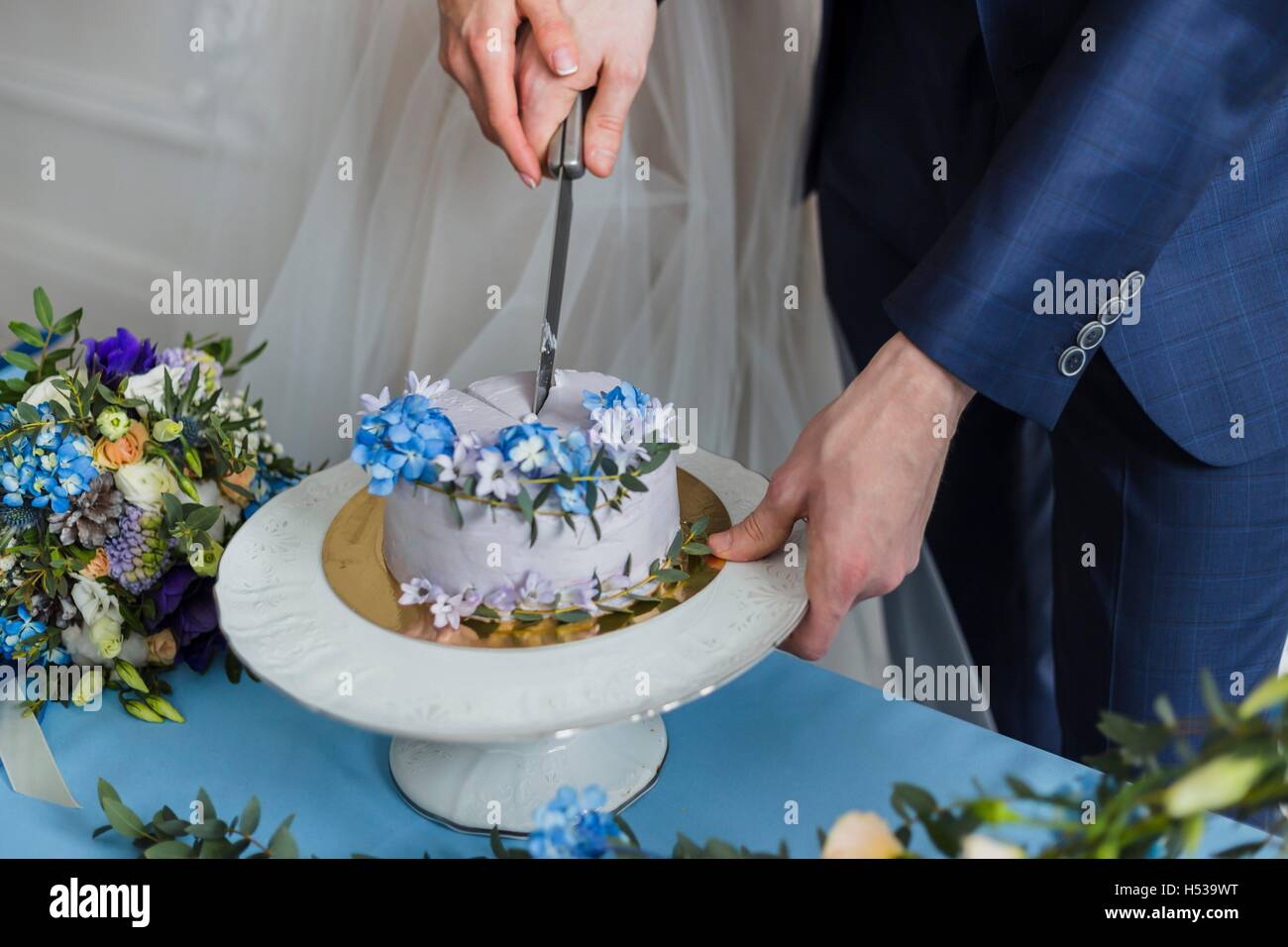 Braut und Bräutigam bei der Hochzeit den Kuchen schneiden Stockfoto