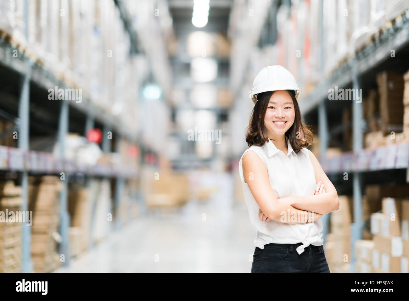 Schöne junge asiatische Ingenieur oder Techniker lächelnd, Lager oder Fabrik Unschärfe Hintergrund, Industrie oder Logistik-Konzept Stockfoto