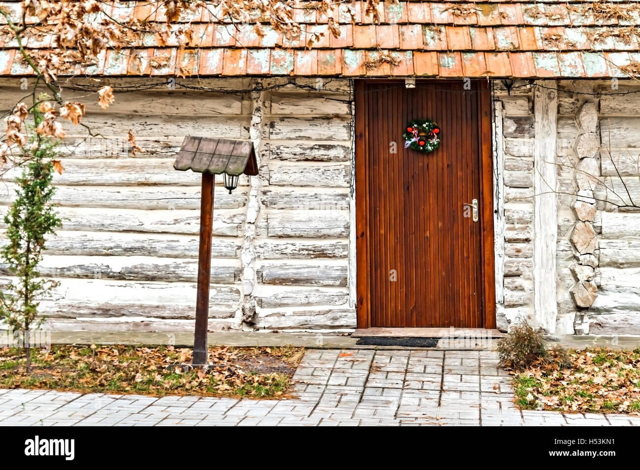 Weihnachtskranz an der Tür eines Holzhauses. Stockfoto