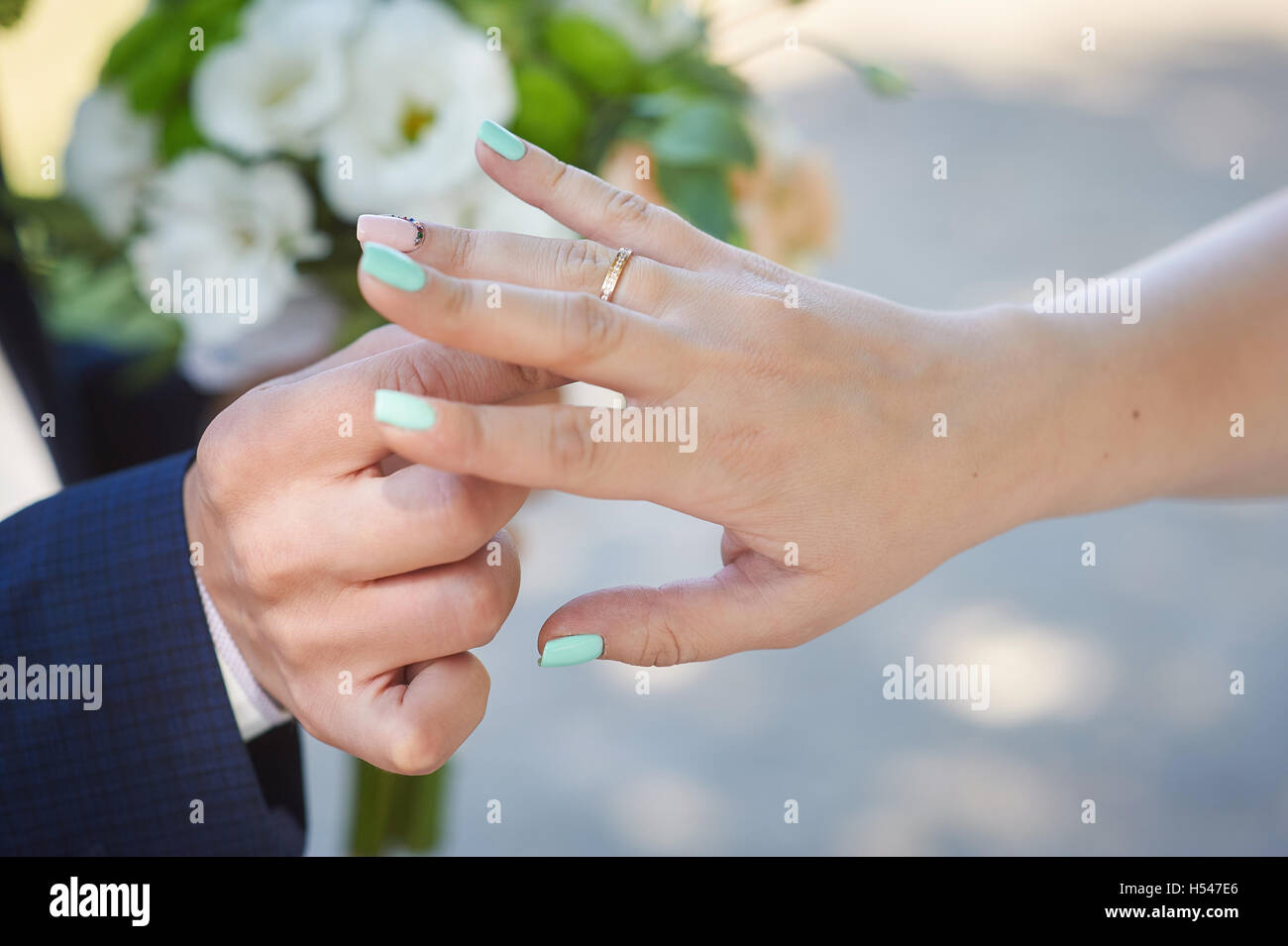 Bräutigam trägt Braut einen Ehering am finger Stockfoto