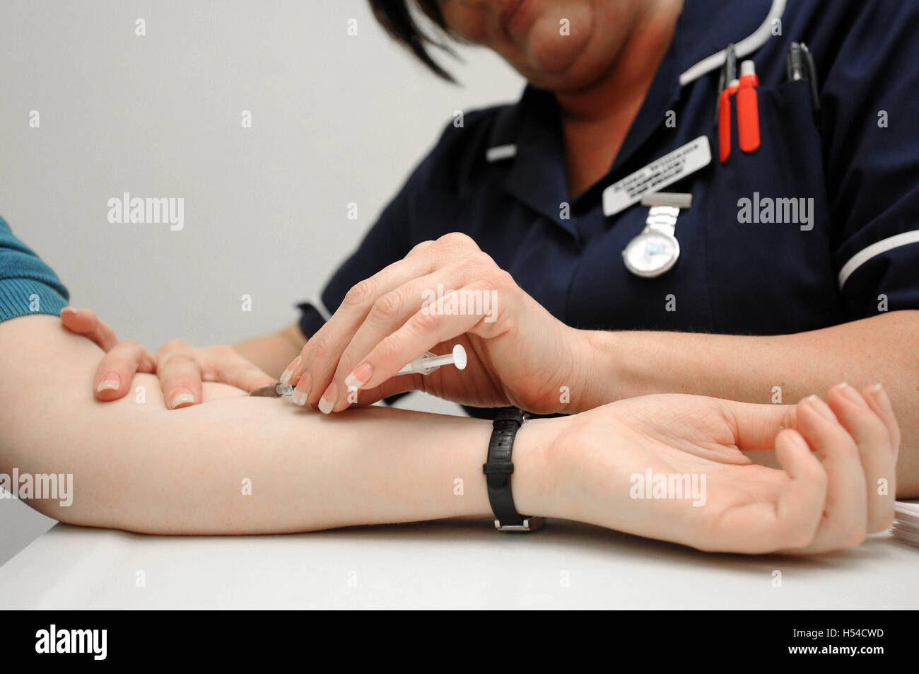 Eine Krankenschwester nimmt Blut während eines Blut-Tests in einer Arztpraxis. Stockfoto