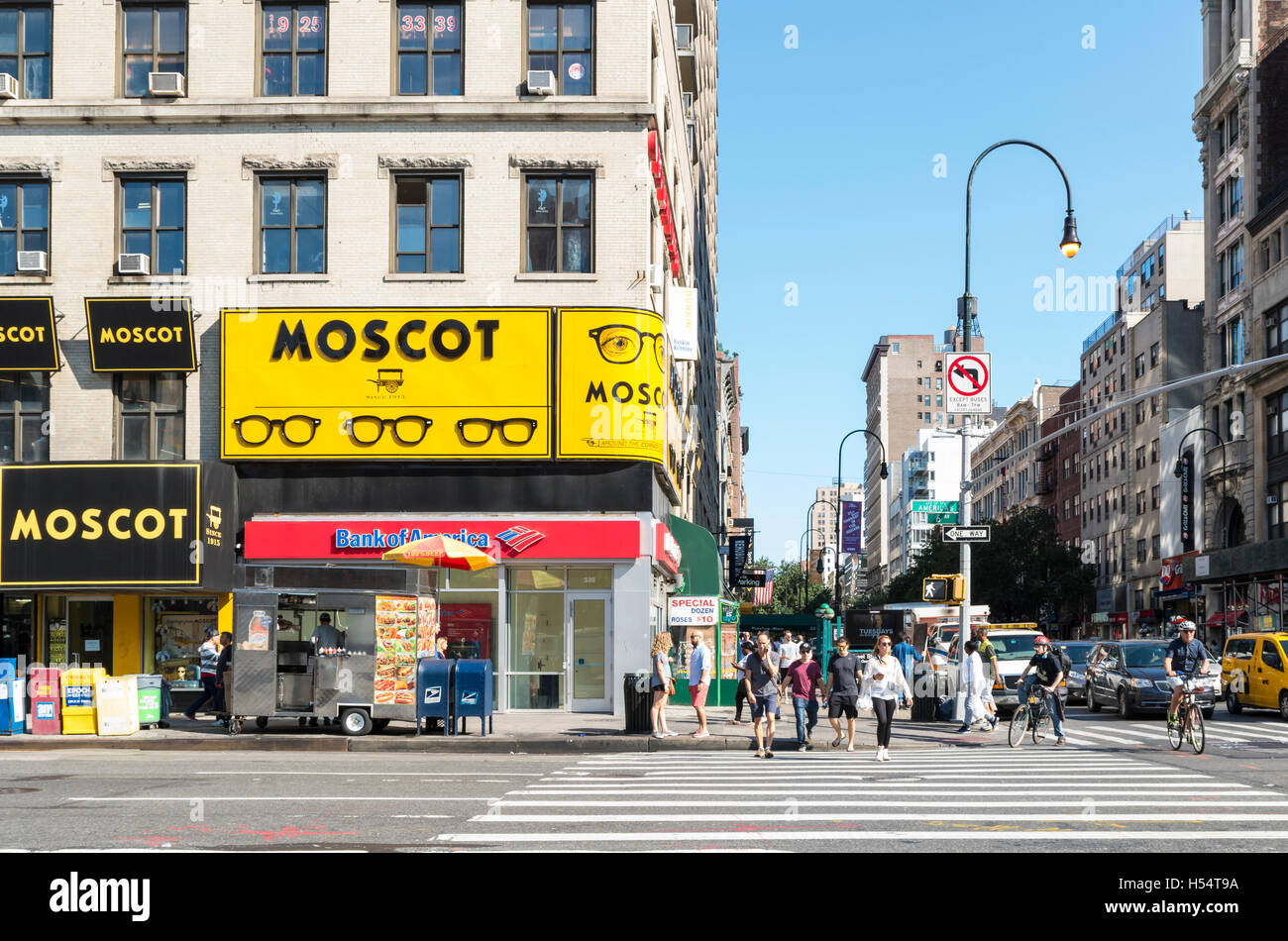 Ansicht der Schnittpunkt der 14th Street mit 6th Avenue, mit Moscot Brillen Shop und Menschen beim Überqueren der Straße Stockfoto