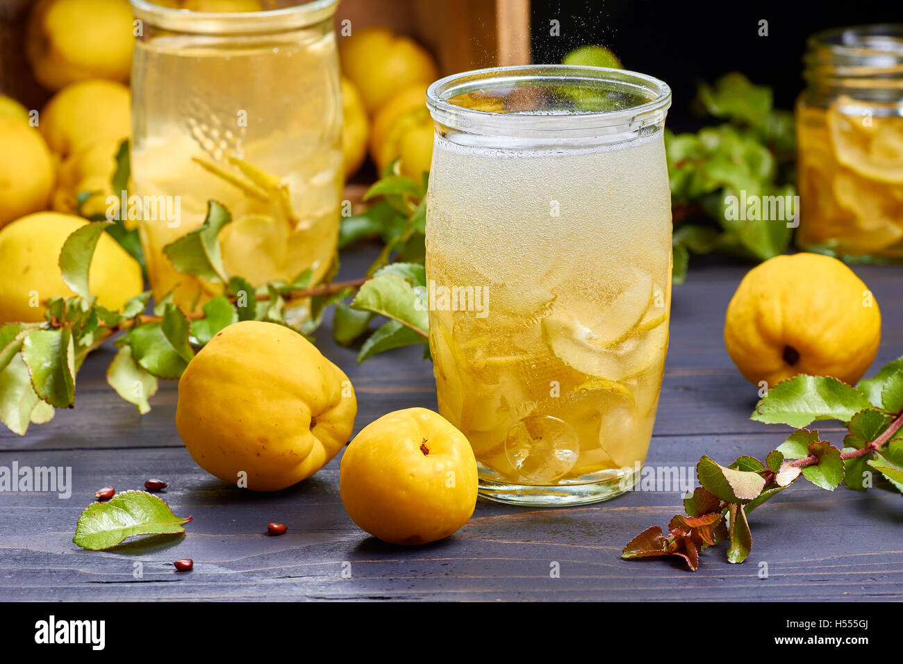 kohlensäurehaltige Getränke mit Sirup aus japanische Quitte auf frisches Obst Hintergrund Stockfoto