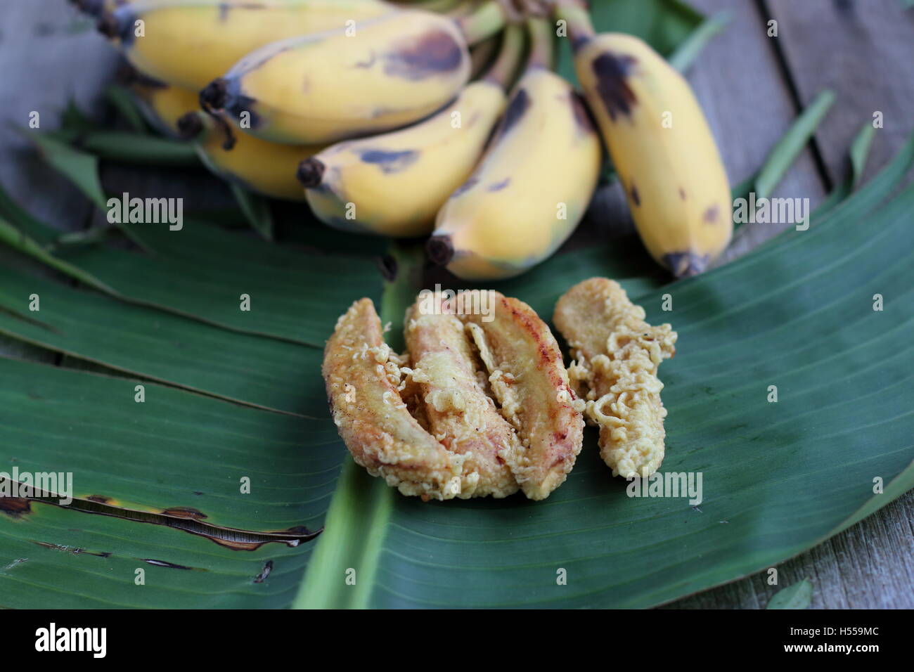 Nahaufnahme von Fried Ducasse Bananen oder auch bekannt als Zucker Bananen auf Bananenblatt und Holzbrett Stockfoto