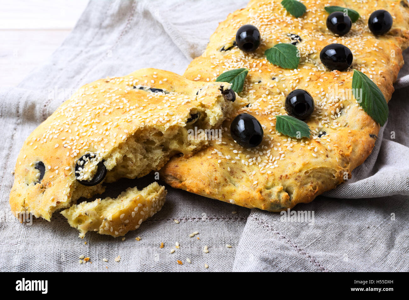 Ein Stück italienisches Brot Focaccia mit Oliven und Kräutern. Traditionelle italienische Hausbrot Focaccia. Stockfoto