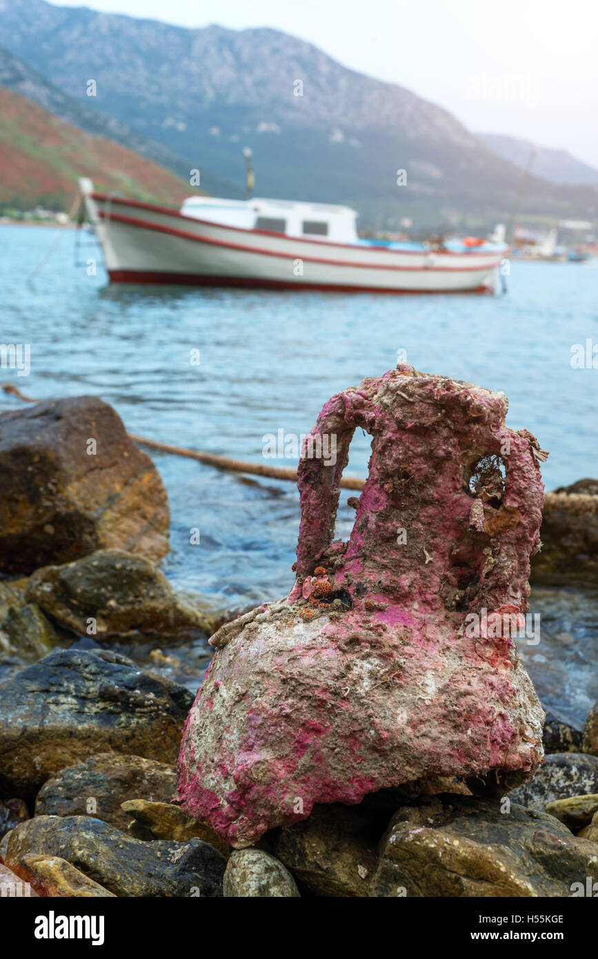 alte Amphore auf Steinen, nahe dem Meer Stockfoto