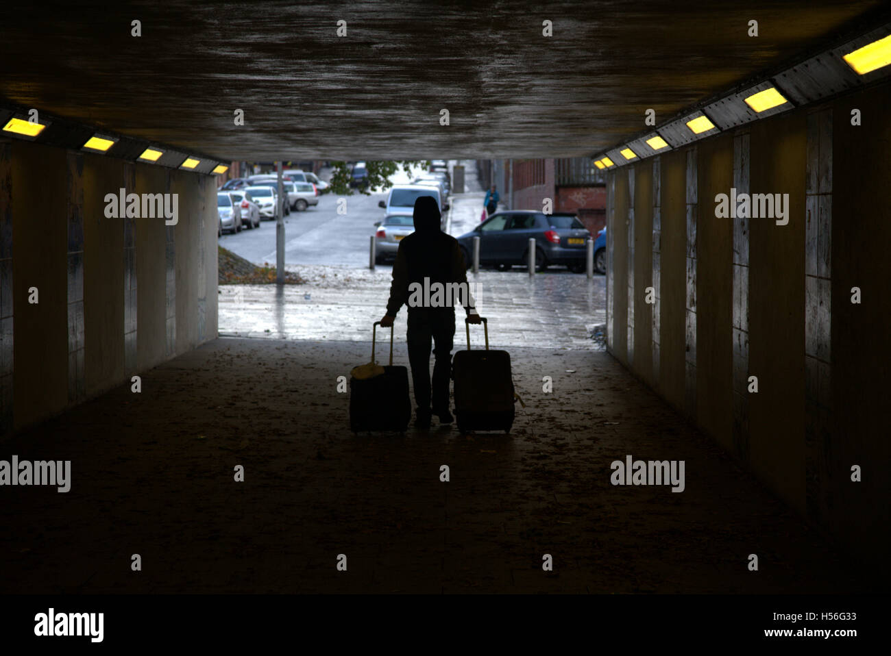 Silhouetten von Menschen in der Stadt Mann mit Gepäck zwei Fälle oder trollys Stockfoto