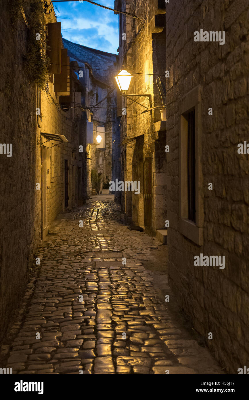 Beleuchtete kleine Gasse mit einer Laterne bei Nacht, Trogir, Altstadt, Dalmatien, Kroatien Stockfoto
