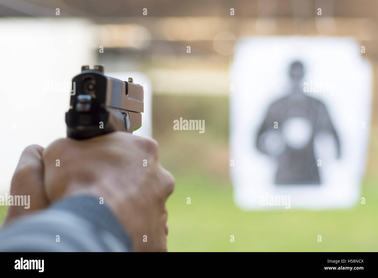 Mann feuerte Pistole bei Target Shooting Range Stockfoto