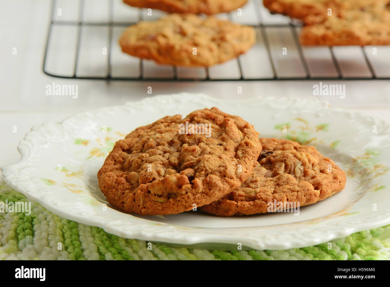 Frisch gebackene Kekse Haferflocken Rosinen Walnuss gebacken frisch Vintage mit Cookies Kühlung auf Rack im Hintergrund.  Schuss in natürlichem Licht Stockfoto
