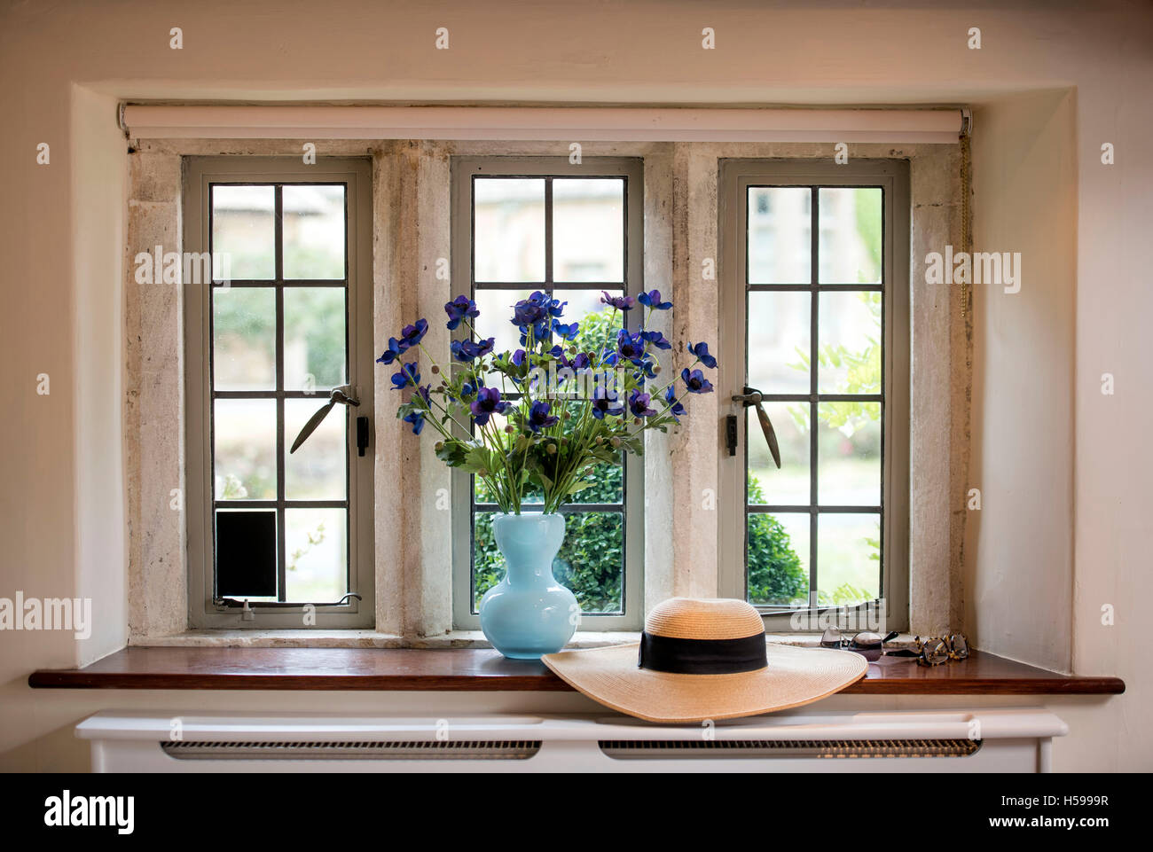 Ein Blumenhut Anordnung und im Sommer auf einer Hütte Küchenfenster Stockfoto