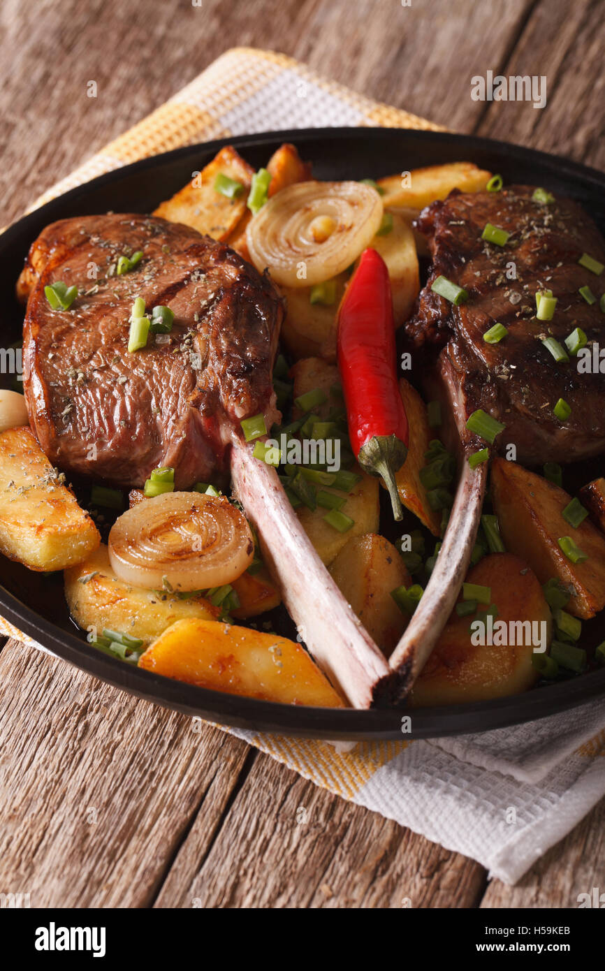 Rindersteak mit Chili und als Beilage Kartoffeln hautnah auf einem Teller. Vertikal Stockfoto