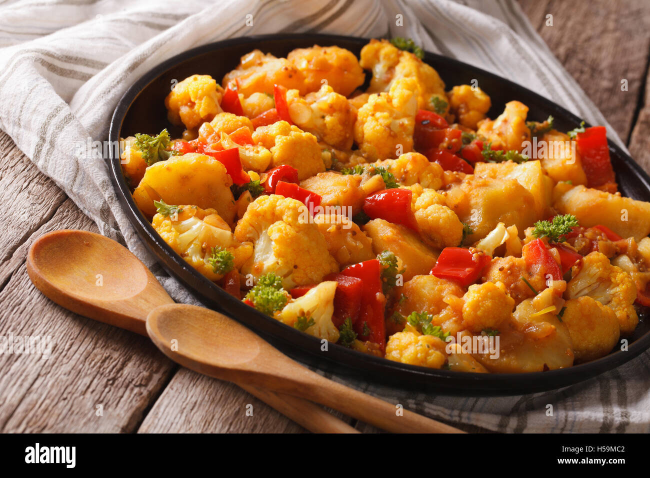 Indische vegetarische Aloo Gobi Nahaufnahme auf einer Platte. Horizontal, rustikal Stockfoto