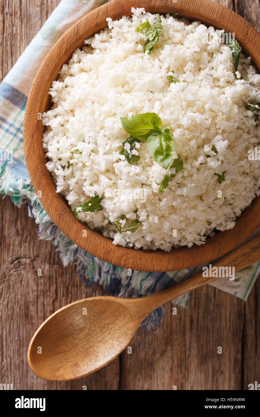 Paleo Essen: Blumenkohl Reis mit Kräutern Nahaufnahme in die Schüssel. Vertikale Ansicht von oben Stockfoto