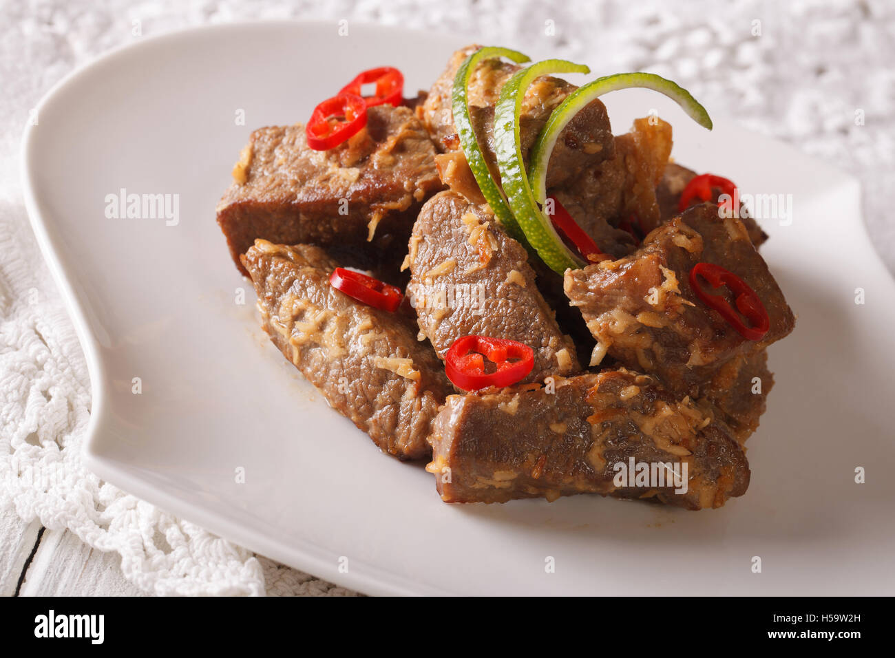 Indonesische Küche: Beef Rendang geschmort in Kokosmilch mit Gewürzen Nahaufnahme auf einer Platte. Horizontale Stockfoto