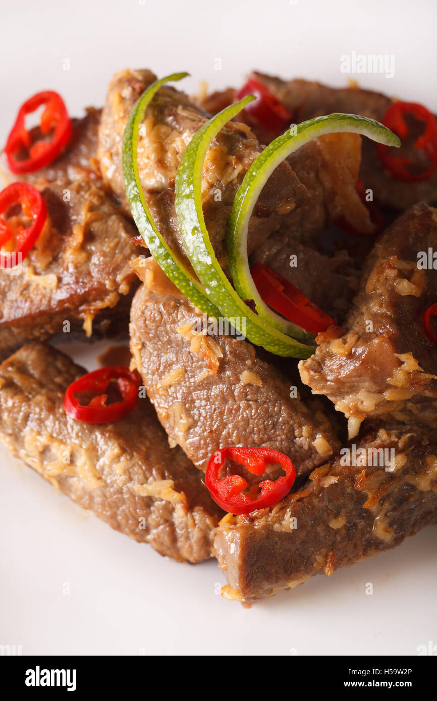 Indonesische Küche: Beef Rendang geschmort in Kokosmilch mit Gewürzen Nahaufnahme auf einer Platte. Vertikal Stockfoto