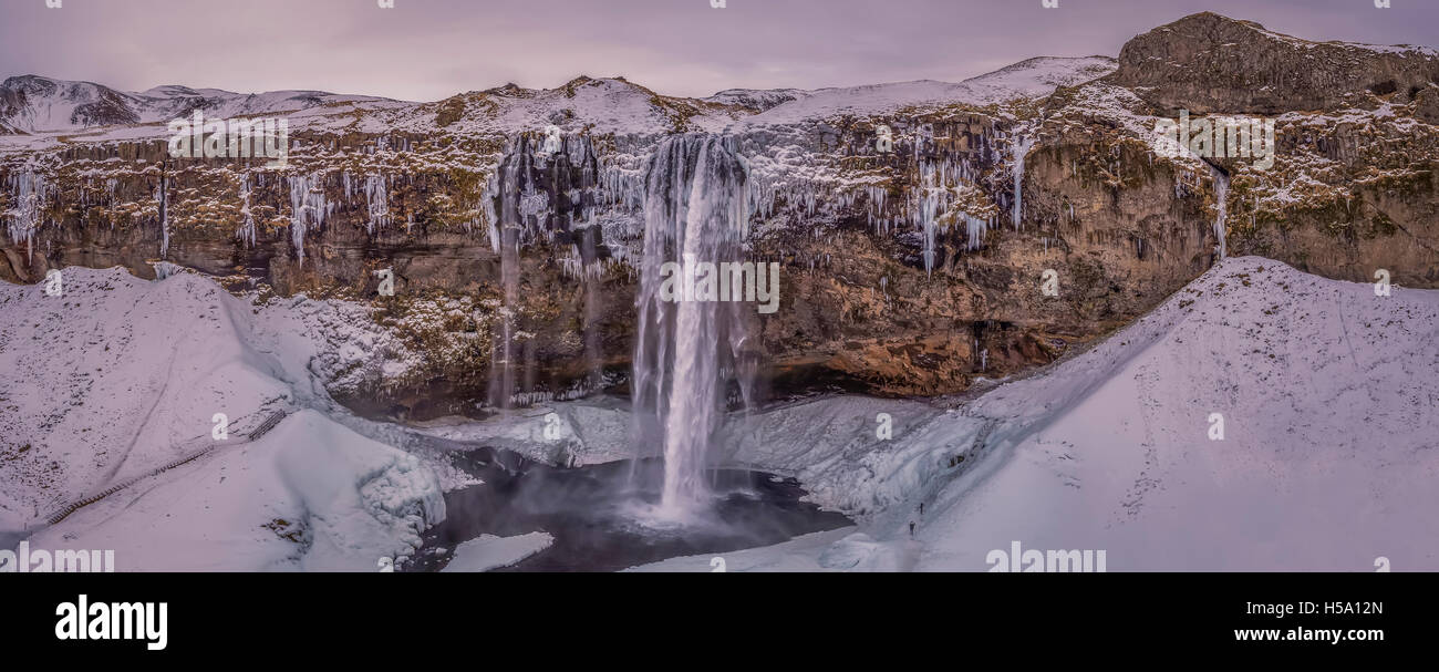 Seljalandsfoss im Winter, einem einzigartigen Wasserfall mit einem Wanderweg hinter sich. Dieses Bild wird mit einer Drohne geschossen. Stockfoto