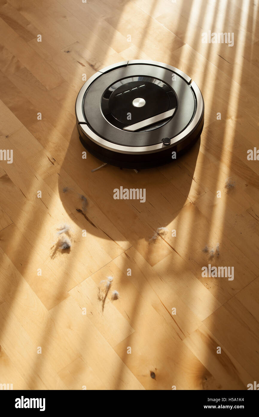 Roboter-Staubsauger auf Holz Laminatboden smart Reinigung Technik Staub Stockfoto