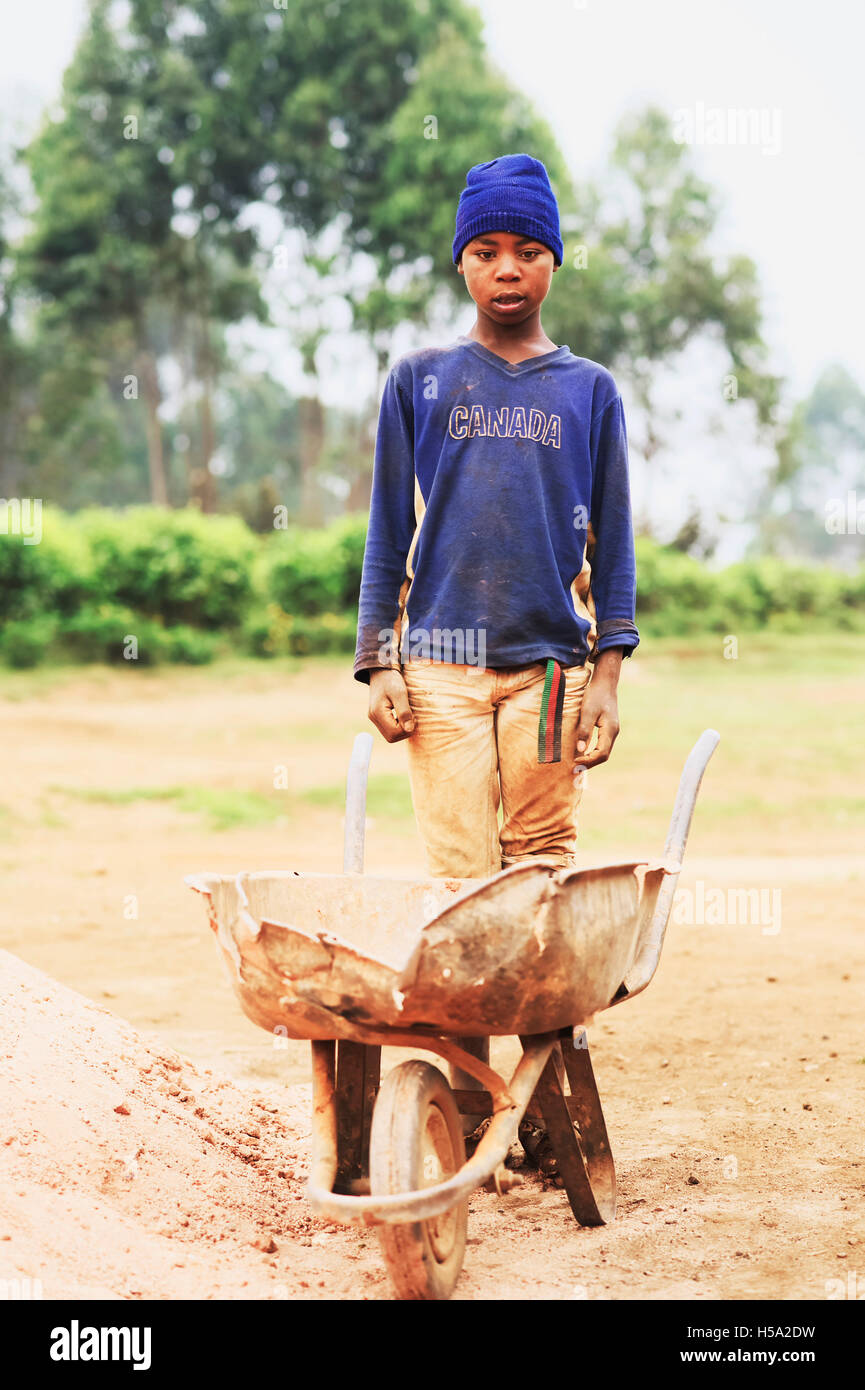 Ein Porträt von einem Kind Arbeiter im ländlichen Uganda, auf einer Baustelle in Ost-Afrika arbeitet anstatt zur Schule zu gehen Stockfoto