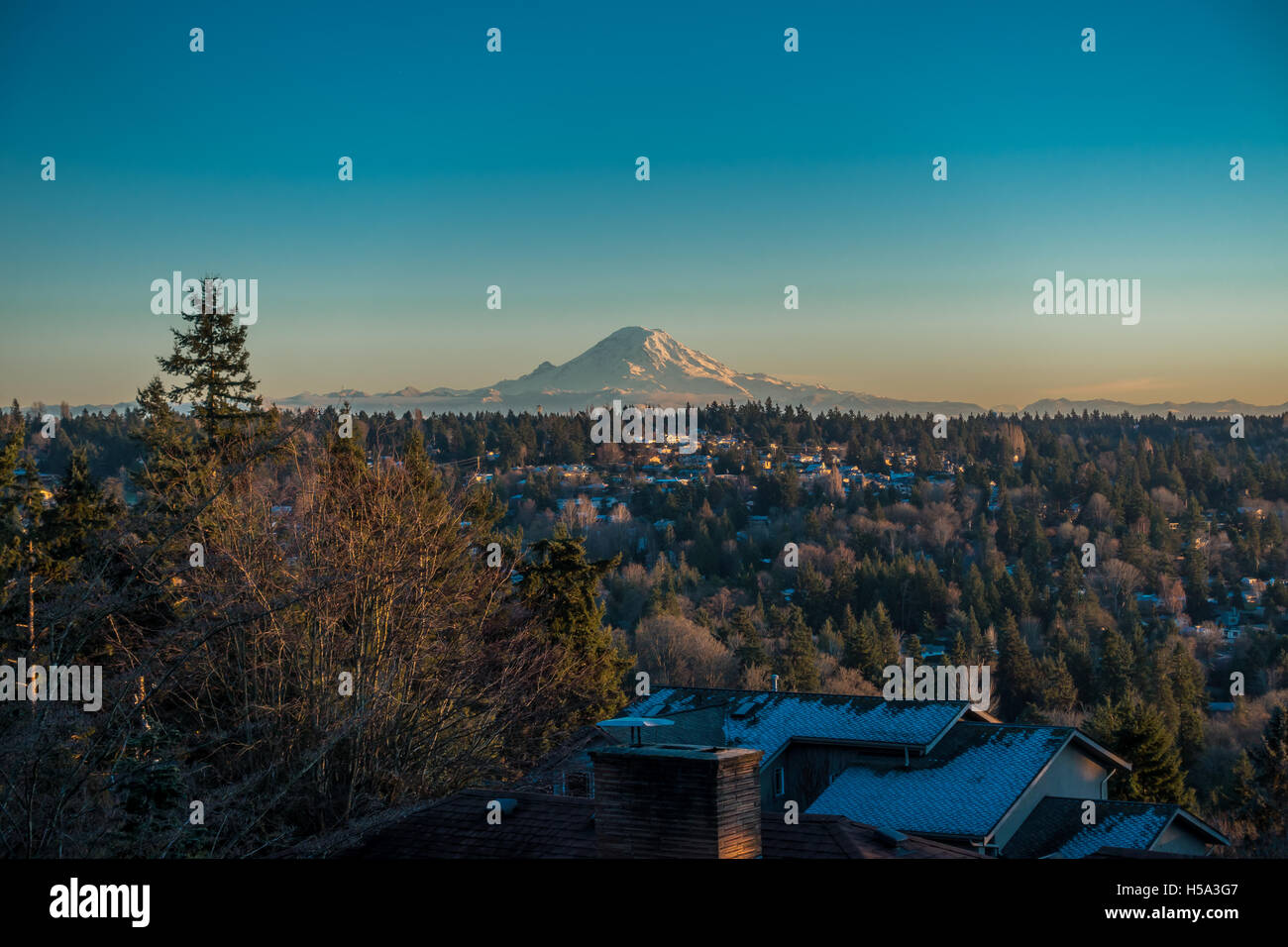 Ein Blick auf Mount Rainier an einem klaren Wintertag mit Häusern im Vordergrund. Schuss von Burien, Washington aufgenommen. Stockfoto