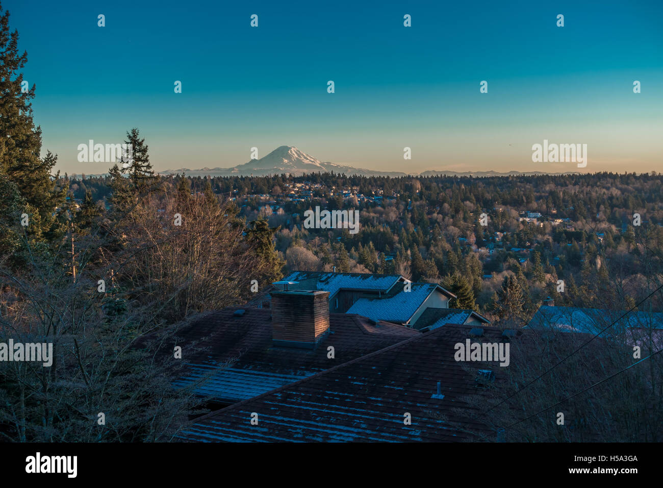 Ein Blick auf Mount Rainier an einem klaren Wintertag mit Häusern im Vordergrund. Schuss von Burien, Washington aufgenommen. Stockfoto