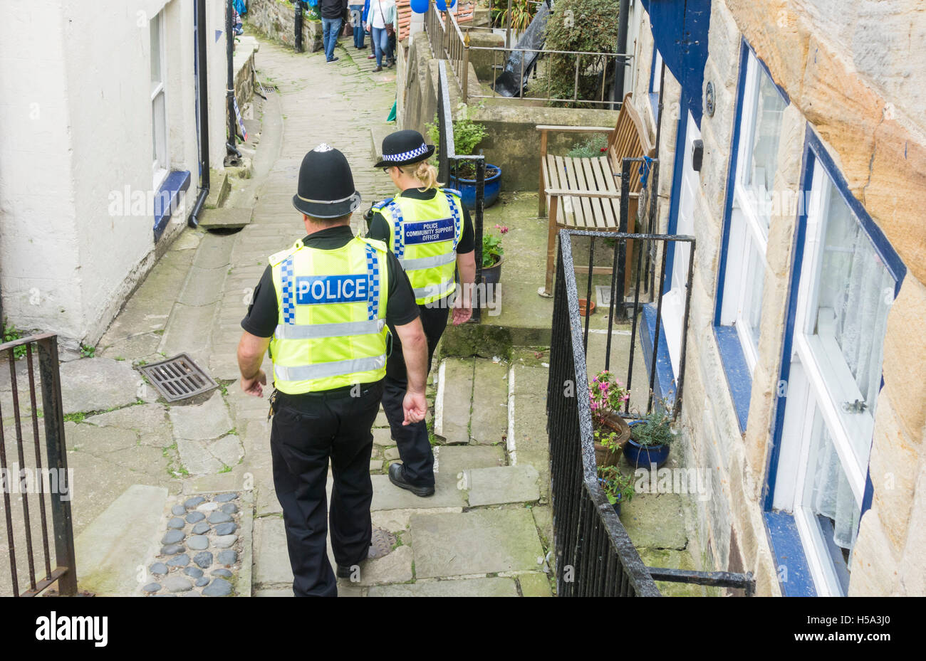 Männlicher Polizist und weibliche Polizei unterstützen Gemeinschaft Offizier in Dorfstraße in England. UK Stockfoto