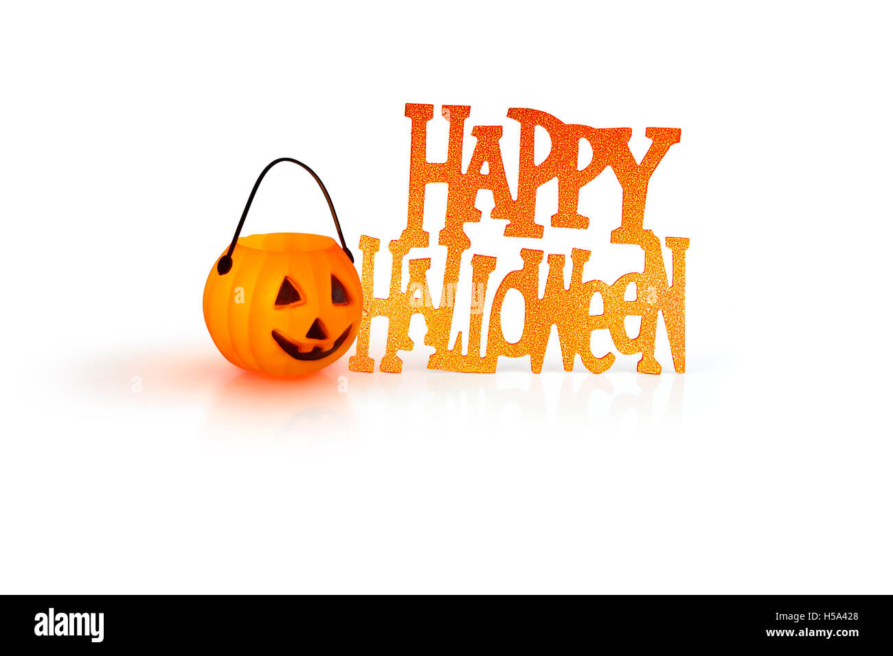 Halloween-Konzept mit einer orange glühenden Kürbis Form Teelicht Kerze-Halter und ein Happy Halloween Zeichen auf weißem Hintergrund Stockfoto
