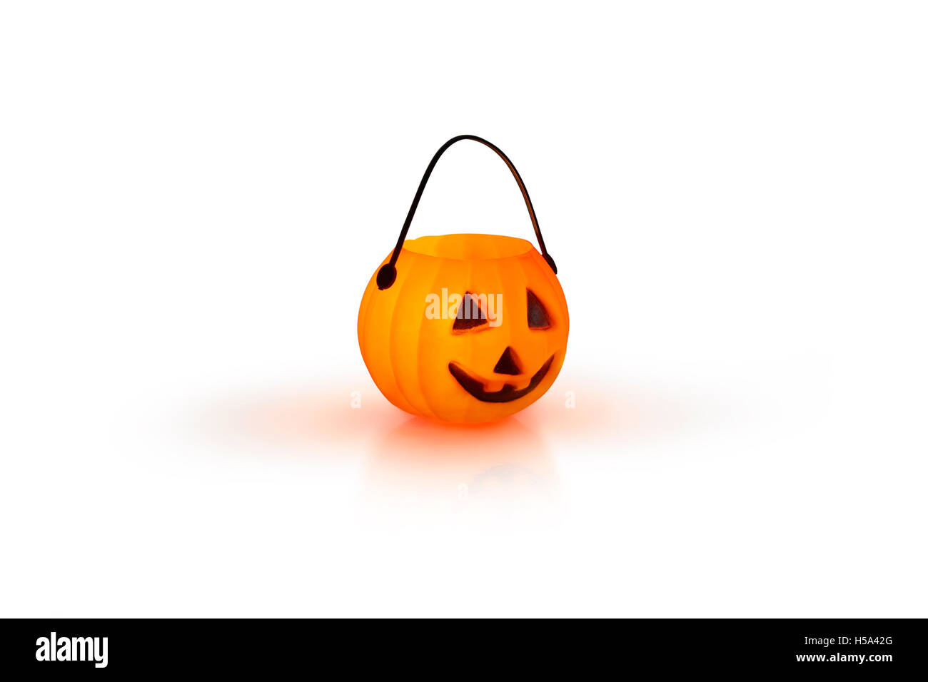 Halloween-Konzept mit einem orange glühenden Kürbis Form Teelicht Kerzenhalter auf weißem Hintergrund Stockfoto