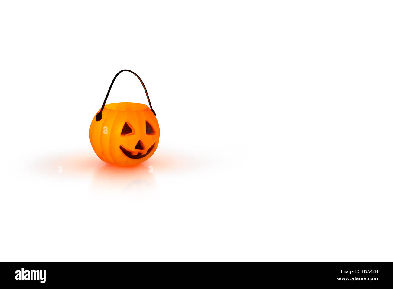 Halloween-Konzept mit einem orange glühenden Kürbis Form Teelicht Kerzenhalter auf weißem Hintergrund Stockfoto