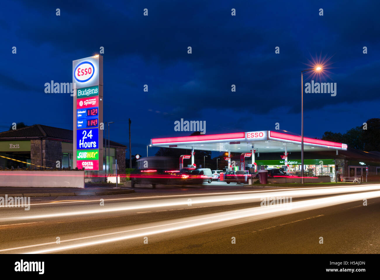 Ein Tankstelle Vorplatz beleuchtet in der Abenddämmerung. Stockfoto